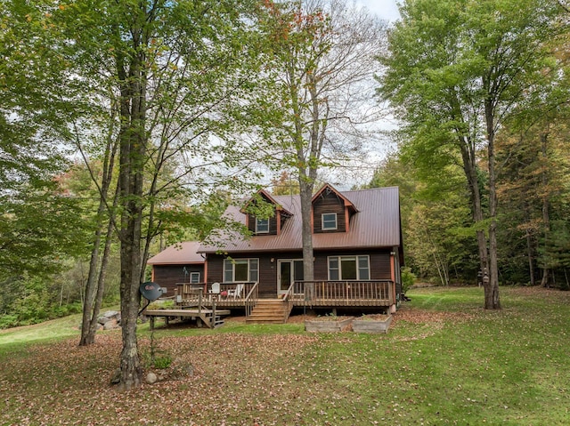 view of front of property with a deck and a front lawn