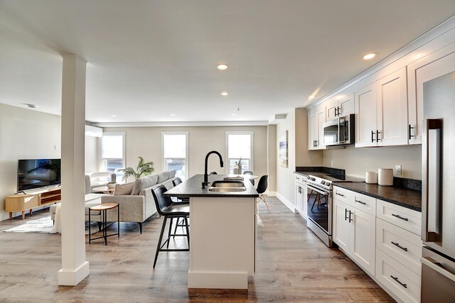 621 Islington St Unit B, Portsmouth, NH 03801 - kitchen featuring appliances with stainless steel finishes, a sink, dark countertops, open floor plan, and healthy amount of natural light