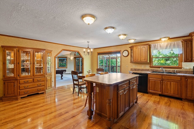 kitchen with hanging light fixtures, a kitchen island, black dishwasher, billiards, and light hardwood / wood-style floors