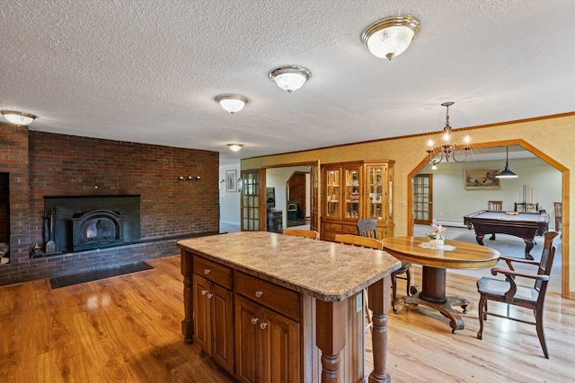 kitchen featuring a kitchen island, a textured ceiling, decorative light fixtures, billiards, and light hardwood / wood-style floors