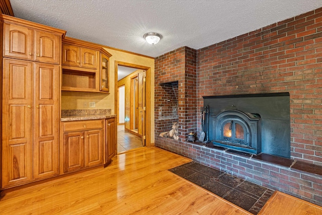 kitchen with light hardwood / wood-style floors, brick wall, and a textured ceiling