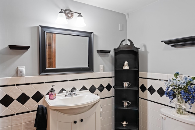 bathroom with tile walls, vanity, and toilet