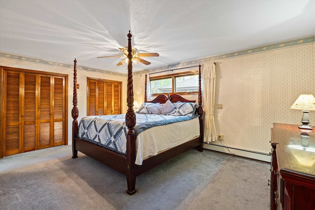 bedroom with ceiling fan, baseboard heating, carpet floors, and a textured ceiling