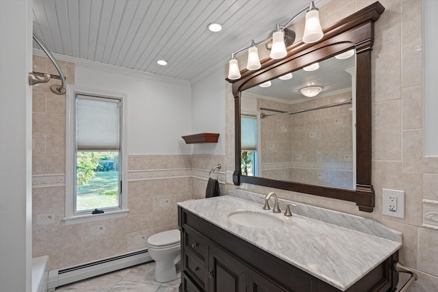 bathroom featuring vanity, baseboard heating, toilet, and tile walls