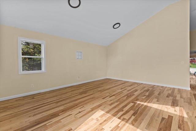 unfurnished room featuring light hardwood / wood-style flooring and vaulted ceiling