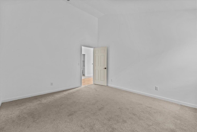 empty room featuring high vaulted ceiling and carpet floors