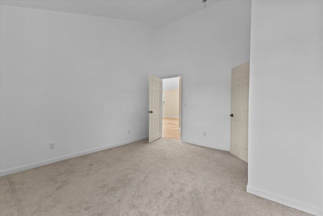 carpeted empty room featuring high vaulted ceiling