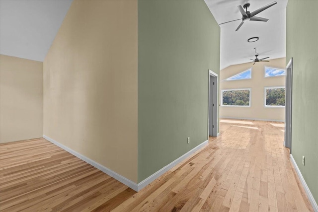 hallway with light hardwood / wood-style flooring and high vaulted ceiling