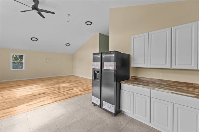 kitchen with white cabinets, light hardwood / wood-style flooring, black refrigerator with ice dispenser, and wood counters