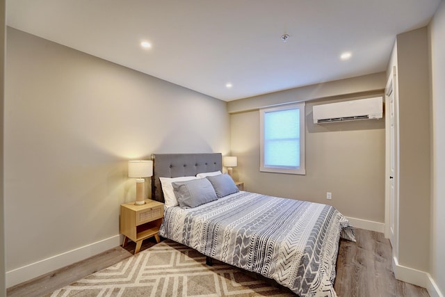 bedroom featuring a wall mounted AC and wood-type flooring