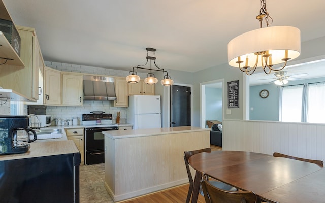 kitchen with hanging light fixtures, white fridge, black electric range, a center island, and wall chimney range hood