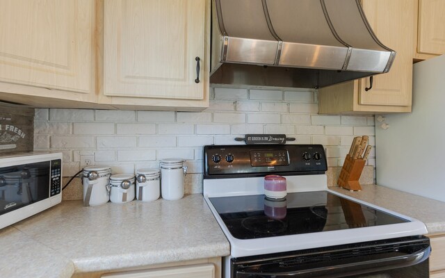 kitchen featuring white range with electric cooktop, light brown cabinets, and range hood