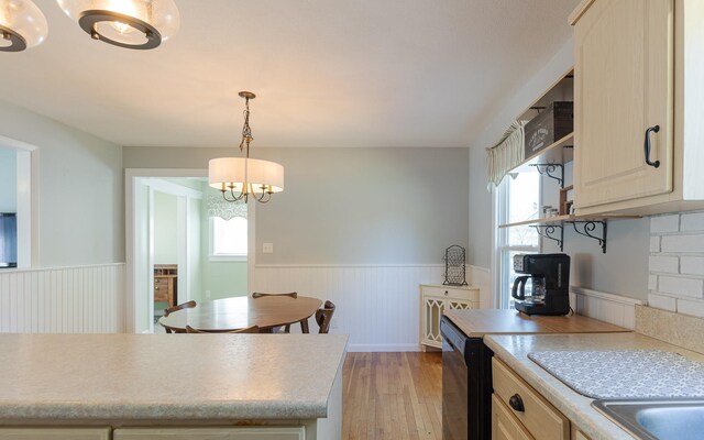 kitchen with pendant lighting, backsplash, a chandelier, dishwasher, and light wood-type flooring