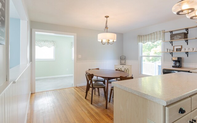 dining area featuring a healthy amount of sunlight, light hardwood / wood-style flooring, and a chandelier