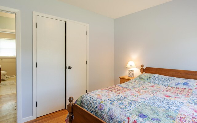 bedroom with light wood-type flooring and a closet