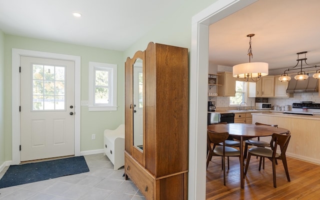 kitchen featuring light hardwood / wood-style floors, light brown cabinets, pendant lighting, and a wealth of natural light