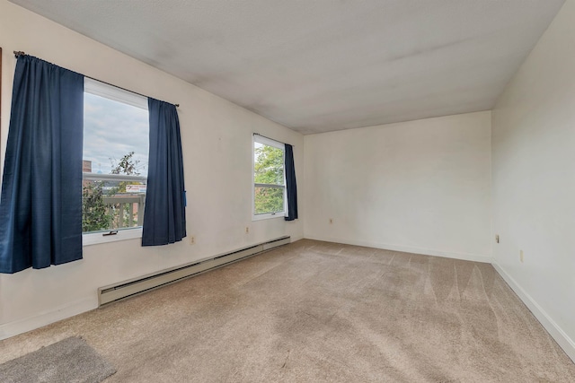 carpeted spare room with a baseboard heating unit