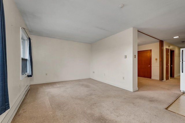 carpeted empty room featuring baseboards and a baseboard heating unit