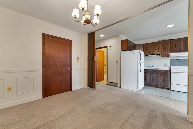 kitchen with white appliances, dark brown cabinets, sink, light carpet, and a notable chandelier