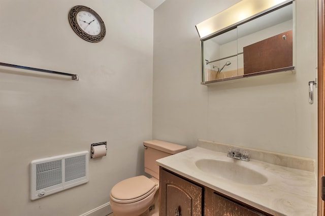 bathroom featuring vanity, heating unit, and toilet