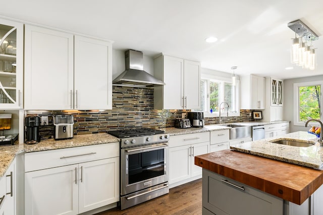 kitchen with white cabinets, appliances with stainless steel finishes, wall chimney exhaust hood, and sink