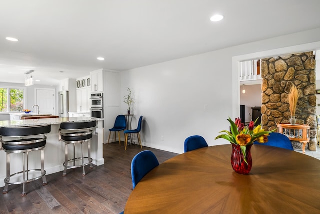 dining area with sink and dark hardwood / wood-style flooring