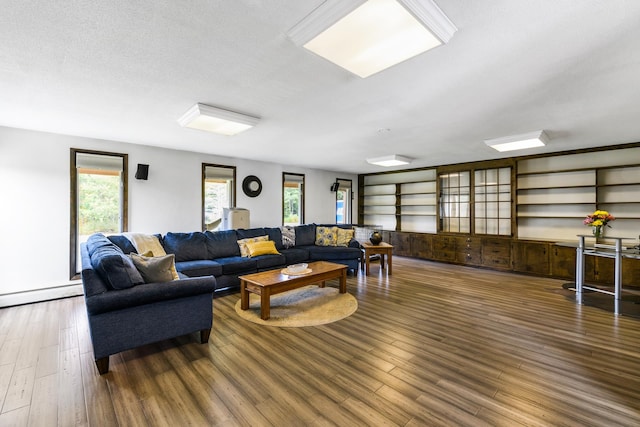 living room featuring a textured ceiling, dark hardwood / wood-style flooring, and a wealth of natural light