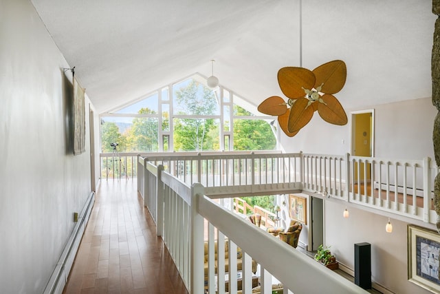 hallway with baseboard heating, lofted ceiling, and hardwood / wood-style floors