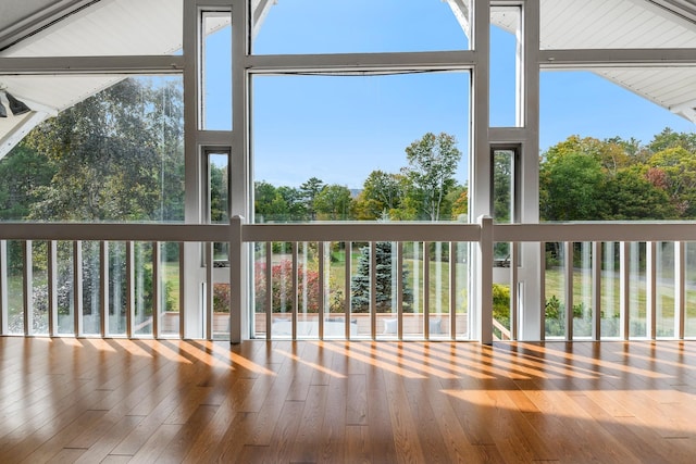 unfurnished sunroom featuring vaulted ceiling with beams