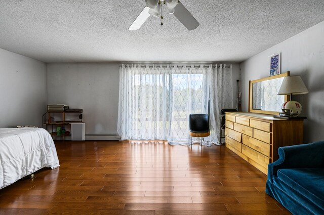 bedroom featuring a textured ceiling, baseboard heating, dark hardwood / wood-style floors, and ceiling fan