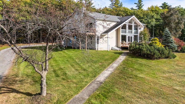 back of house featuring a sunroom, a yard, and a wooden deck