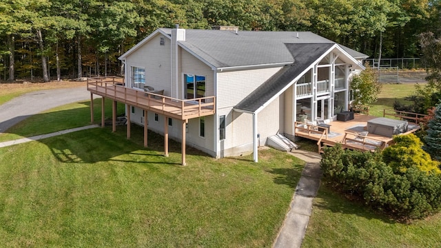 rear view of property with a wooden deck and a yard