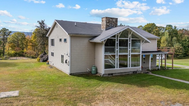 back of house featuring a sunroom and a yard