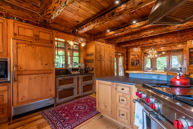 kitchen with beam ceiling, decorative light fixtures, a chandelier, stainless steel appliances, and light hardwood / wood-style floors