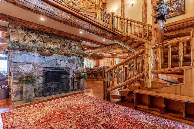 living room with a wealth of natural light, beam ceiling, hardwood / wood-style flooring, and a fireplace