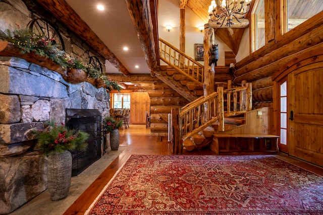 foyer entrance featuring a fireplace, hardwood / wood-style floors, beam ceiling, and log walls