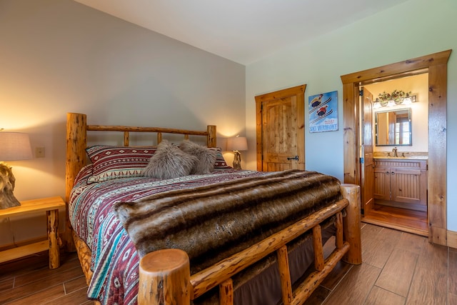 bedroom featuring ensuite bathroom and hardwood / wood-style floors