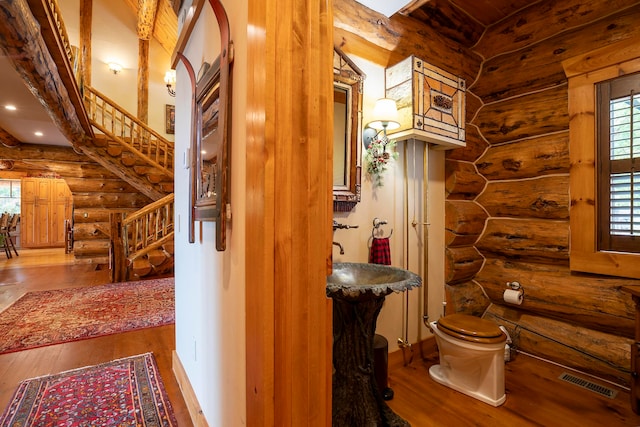 hallway with wood-type flooring, sink, and log walls