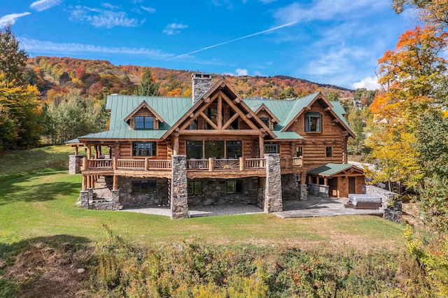 rear view of property featuring a lawn and a mountain view