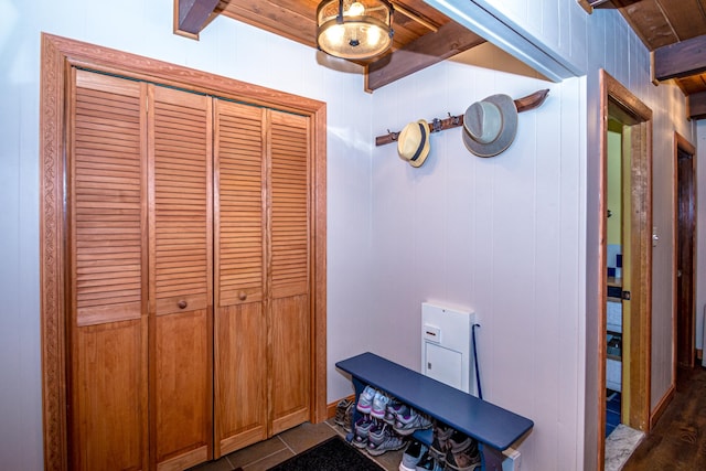 interior space with wood ceiling, wooden walls, tile patterned flooring, and beamed ceiling