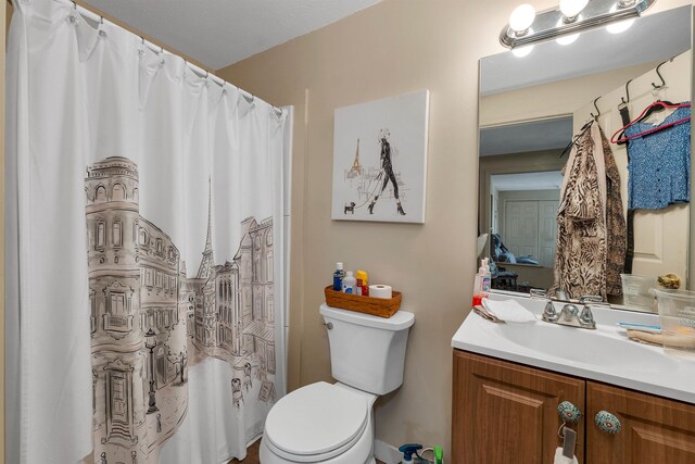 bathroom with curtained shower, vanity, and toilet