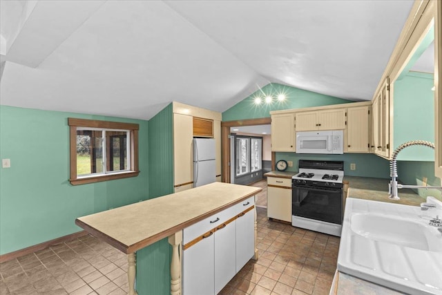 kitchen featuring white appliances, light countertops, a kitchen island, a sink, and lofted ceiling