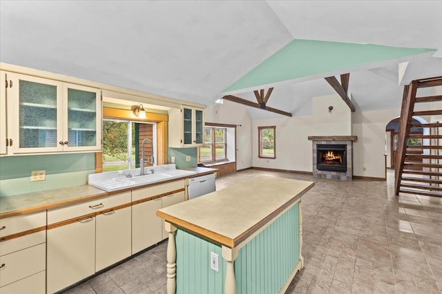 kitchen featuring a warm lit fireplace, light countertops, and plenty of natural light
