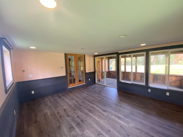 empty room with french doors, recessed lighting, a wainscoted wall, and dark wood finished floors