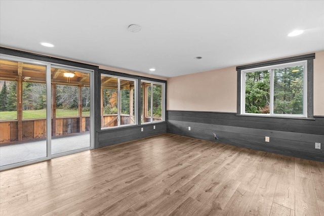 empty room with wainscoting, wood finished floors, and recessed lighting