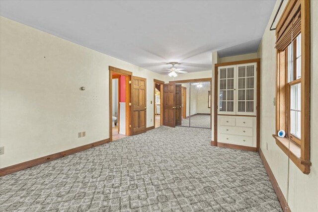 unfurnished sunroom with beamed ceiling and ceiling fan