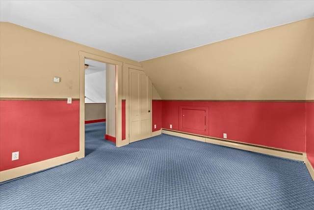 additional living space with lofted ceiling, a baseboard radiator, carpet flooring, and baseboards