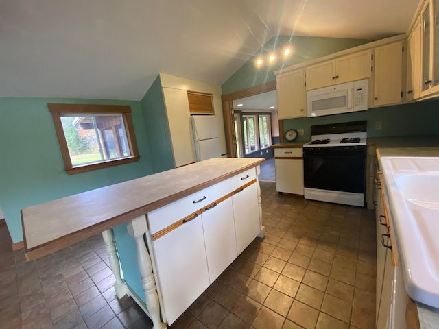 kitchen featuring lofted ceiling, white appliances, white cabinets, and a sink