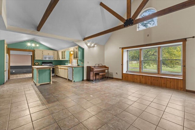 kitchen with lofted ceiling, a sink, open floor plan, dishwasher, and a fireplace