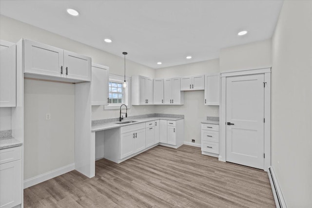 kitchen featuring white cabinets, pendant lighting, and sink